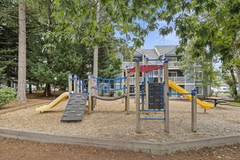 A playground with a yellow slide and a red and blue structure.